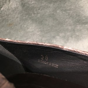 Op de afbeelding: Close-up van de binnenkant van een bruine leren schoen. De binnenkant van de schoen is zwart, met de maat "36" en de tekst "WOMEN'S SIZE" in het wit gedrukt.