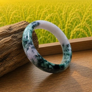 May include: A smooth, circular bangle bracelet crafted from polished stone, featuring a marbled pattern of deep forest green and translucent white sections. The bracelet has a rounded profile and a glossy finish that reflects light across its surface.