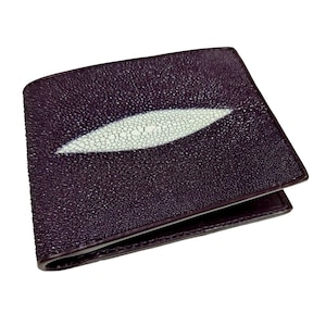 May include: A dark purple leather wallet with a white stingray skin inlay. The wallet has a smooth, textured surface and a folded design.