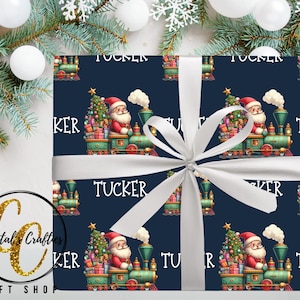 May include: Christmas-themed gift wrap featuring a repeating pattern of Santa Claus riding a green train with a Christmas tree and gifts. The word "Tucker" is printed on the wrapping paper. A white ribbon is tied around the gift. The background includes Christmas decorations.
