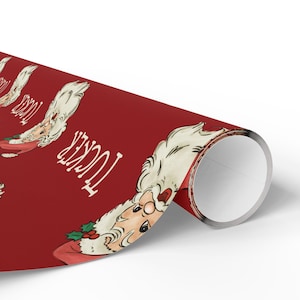 May include: Red wrapping paper with a repeating pattern of a cartoon Santa Claus with white hair and beard. The text "Tucker" is printed on the paper.