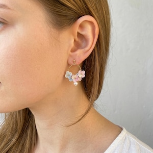 May include: A white ceramic mug with a black handle and the text "But First, Coffee" in a bold, black font. The mug is filled with a dark liquid, probably coffee, and rests on a light-coloured surface.