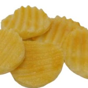 May include: A close-up of several golden-yellow, ridged potato crisps. The crisps have a wavy texture and are slightly translucent, suggesting they are freshly made. The crisps are arranged in a small pile against a white background.
