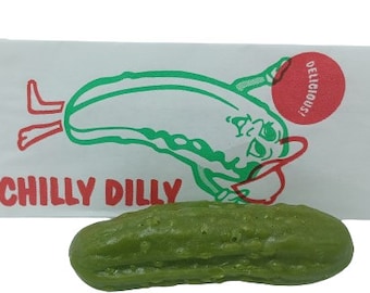 May include: A green pickle shaped like a cartoon pickle with the words "Chilly Dilly" and "Delicious!" on a white paper bag.