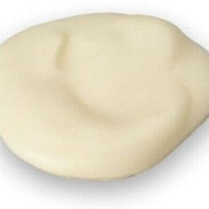 Może przedstawiać: Zbliżenie na gładki, kremowy, okrągły silikonowy odlew. Odlew ma kształt ludzkiego ucha.