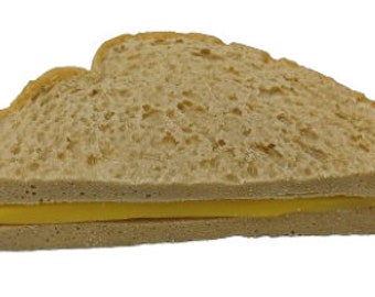 Può includere: Un panino dorato con una fetta di formaggio giallo al centro.
