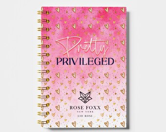 May include: A pink and white notebook with a gold spiral binding. The cover features a watercolor background with gold hearts and the text "Pretty Privileged" in pink and gold lettering. The bottom of the cover has the text "Rose Foxx New York LIO Rose" in black lettering.