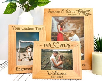 May include: Three wooden picture frames with engraved text. The top frame says "Jannie & Steve Martin" with a leafy design. The middle frame says "Your Custom Text" and "Engraved". The bottom frame says "mr ♥ mrs Williams EST. 2020".