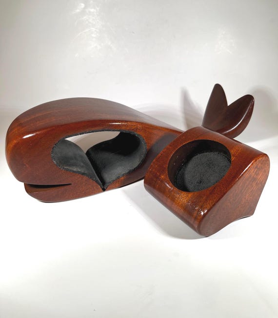 A hand-carved wooden whale with a secret hidden compartment inside — nautical folk art that doubles as a stash box.