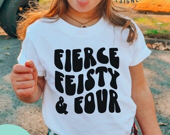 May include: A white t-shirt with the words "FIERCE FEISTY & FOUR" in black, worn by a young child. The shirt has rolled-up sleeves. The image also includes text that says "the COSMIC STUDIO shop" and "SVG SOLID & PNG SOLID".