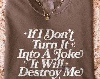 May include: A brown t-shirt with white text that reads "If I Don't Turn It Into A Joke It Will Destroy Me".