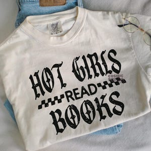 May include: A white t-shirt with a distressed black graphic that reads "Hot Girls Read Books".