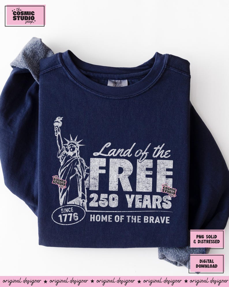 以下が含まれることがあります： 自由の女神と「Land of the Free, 250 Years, Home of the Brave, Since 1776」の文字がプリントされた、白のグラフィックが施された濃い青色のスウェットシャツ。クルーネックと長袖です。