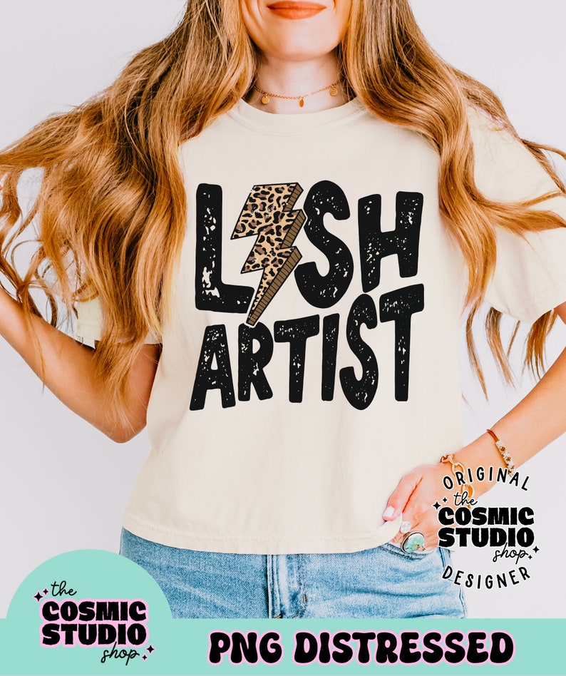 Puede incluir: Un dise&ntilde;o gr&aacute;fico en blanco y negro desgastado con el texto "LASH ARTIST" y un rayo de impresi&oacute;n de leopardo. El dise&ntilde;o est&aacute; en una camiseta beige. El texto "ORIGINAL the COSMIC STUDIO shop DESIGNER" est&aacute; en un c&iacute;rculo blanco con un contorno negro. El texto "PNG DISTRESSED" est&aacute; en un rect&aacute;ngulo rosa con un contorno blanco.