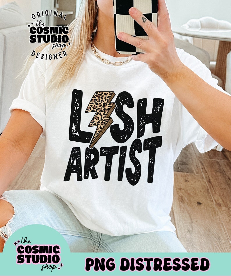 Puede incluir: Camiseta blanca con un gr&aacute;fico negro y estampado de leopardo que dice "Lash Artist" con un rayo.