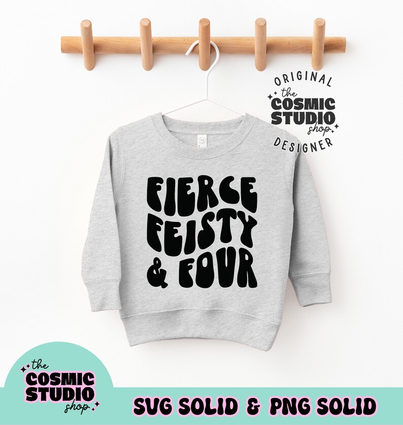 May include: A light gray sweatshirt with the words "FIERCE FEISTY & FOUR" in large, black, bubble letters. The sweatshirt is hanging on a white hanger against a white background. The text "the COSMIC STUDIO shop" is also visible.