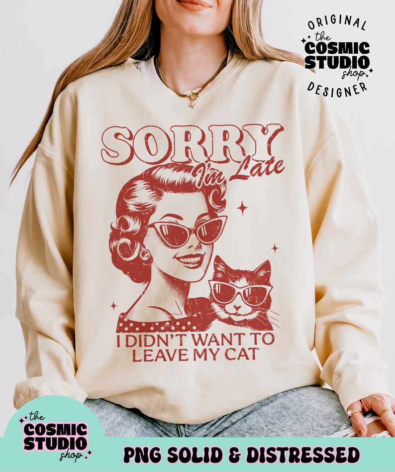 May include: Cream-colored sweatshirt with a distressed red graphic. The graphic features a vintage illustration of a woman and a cat, both wearing sunglasses, with the text "SORRY I'm Late, I didn't want to leave my cat."