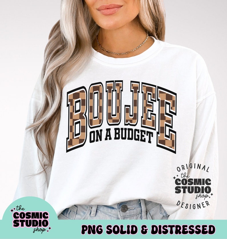 May include: White sweatshirt with the text "BOUJEE ON A BUDGET" in black letters with a brown and black checkered pattern. The text is in a large, bold font. The sweatshirt is being worn by a person. The text "the COSMIC STUDIO shop." is in the bottom left corner of the image. The text "ORIGINAL the COSMIC STUDIO shop. DESIGNER" is in the bottom right corner of the image. The text "PNG SOLID & DISTRESSED" is in the bottom center of the image.