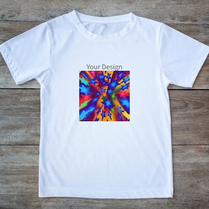 Könnte beinhalten: Weißes T-Shirt mit Rundhalsausschnitt. Das Shirt hat ein farbenfrohes Design aus Sternen in Blau-, Rot- und Gelbtönen mit dem Text "Your Design" über dem Design. Das Shirt wird auf einer Holzoberfläche präsentiert.
