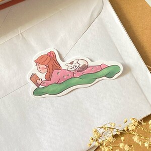 Fille lunatique lisant un livre de fées avec un autocollant de chat - Jolie illustration, décoration d'intérieur confortable