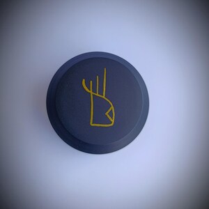 K&ouml;nnte beinhalten: Ein runder, dunkelblauer Untersetzer aus Keramik mit einem goldenen, abstrakten Design.