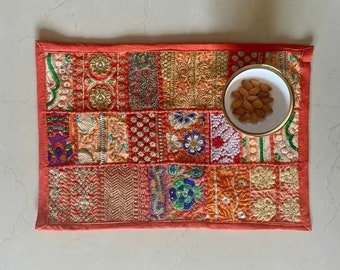 Puede incluir: Un camino de mesa rojo de patchwork con bordados coloridos y un pequeño cuenco blanco lleno de almendras.