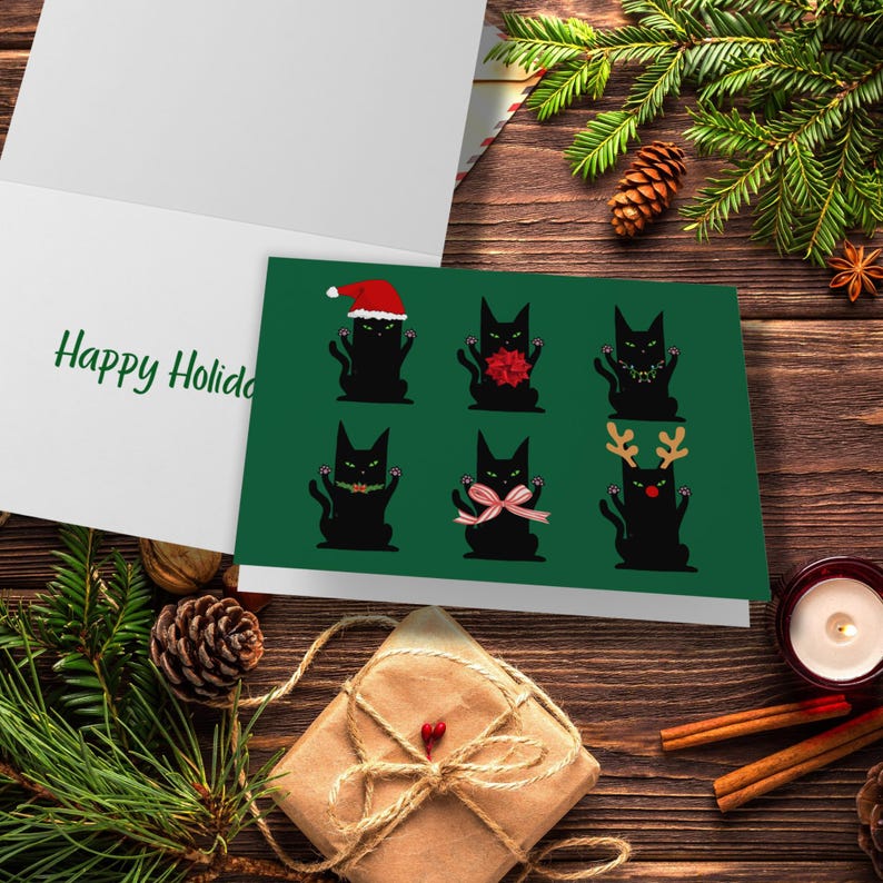 A green card featuring six black cat illustrations. Each cat is in a different holiday outfit. One cat wears a Santa hat, another has a red bow, and a third has a string of lights. The remaining cats are decorated with a green garland, a pink bow, and reindeer antlers.