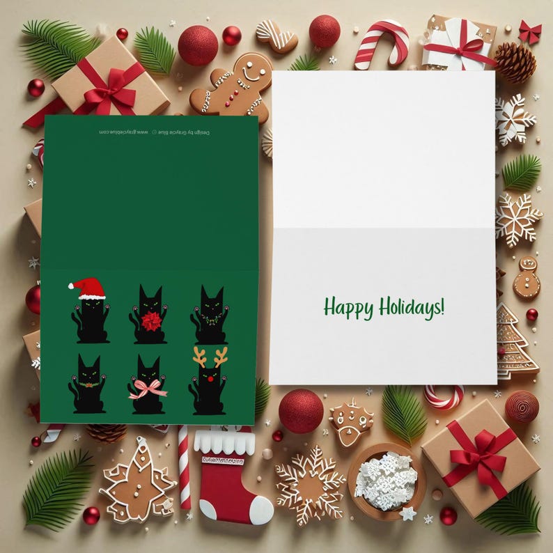 A Christmas-themed greeting card featuring six black cat illustrations. Each cat is depicted in a different festive outfit, including a Santa hat, bow, garland, and reindeer antlers.  An open card is sitting next to it with words, "Happy Holidays" in green script.