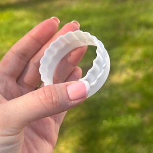 Op de afbeelding: Een set van drie keramische mokken met een gespikkelde, matte afwerking. De mokken zijn in cr&egrave;me, lichtgrijs en donkergrijs. Elke mok heeft een eenvoudig, minimalistisch ontwerp.