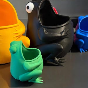 May include: Five frog-shaped planters in different colors, including yellow, black, blue, green, and purple. The planters are all made of plastic and have a wide opening at the top for planting.