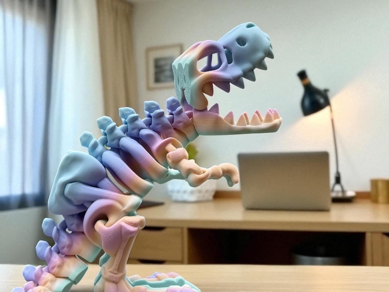 Puede incluir: Una escultura de esqueleto de dinosaurio multicolor en tonos pastel. La pieza decorativa es un esqueleto de T-Rex con la boca abierta, y se exhibe sobre una superficie de madera. Los colores son azul, rosa y amarillo.