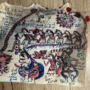 May include: Hand-drawn artwork on aged paper featuring figures, snakes, and floral elements. The artwork includes text in an unknown language, with a central group of dancing figures. The piece has a vintage aesthetic.