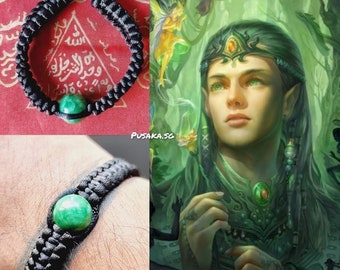 Op de afbeelding: Zwart gevlochten armband met een groene edelsteen. Het armband is te zien op een pols en op een rode achtergrond met Arabische tekst.