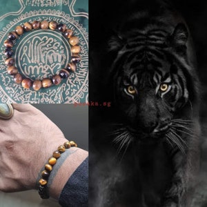 May include: A brown and gold tiger's eye beaded bracelet on a person's wrist. The bracelet is made of round beads with a golden sheen. The bracelet is on a person's wrist with a tattoo.