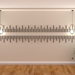 May include: Two black pendant lights with clear glass shades hang from the ceiling in a room with beige walls and a wood floor.  The lights are centered above a wall with a decorative pattern of black vertical lines.