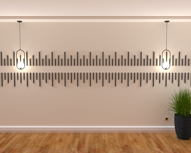 May include: Two black pendant lights with clear glass shades hang from the ceiling in a room with beige walls and a wood floor.  The lights are centered above a wall with a decorative pattern of black vertical lines.