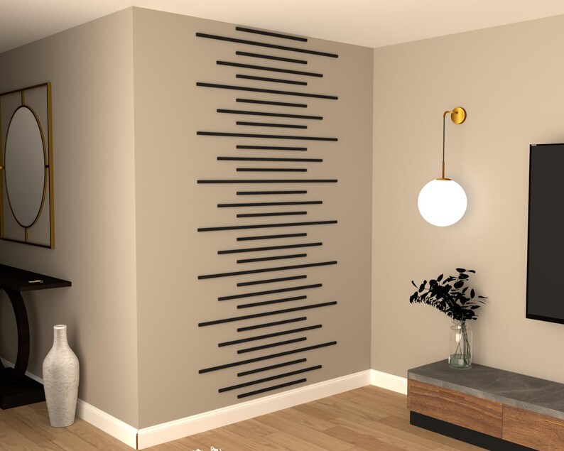 May include: A modern living room interior with a wall accent featuring a geometric pattern of black horizontal lines. A round, white globe light fixture hangs from the ceiling. A small, dark brown table with a vase of dried flowers sits in the corner.