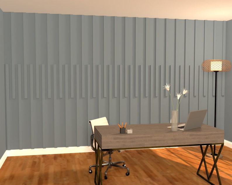 May include: A home office with a gray wall featuring a vertical wood panel design. A wooden desk with a laptop, vase of white flowers, and a lamp sits in front of the wall. A white office chair is pulled up to the desk.