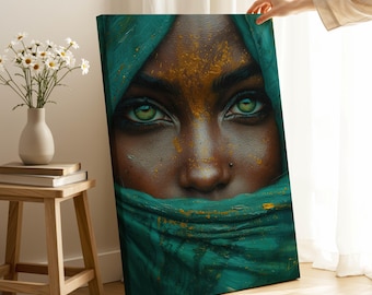 Op de afbeelding: Een canvas print met een close-up van een gezicht met opvallende groene ogen. De persoon draagt een turquoise hoofdbekleding, met gouden accenten op het voorhoofd. Het kunstwerk wordt gepresenteerd tegen een neutrale achtergrond.