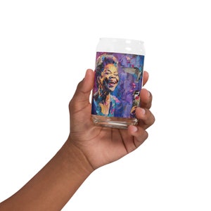 May include: A glass can with a colorful image of a woman singing with a hummingbird flying nearby. The background is a mix of purple, blue, and pink.