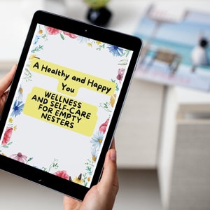 May include: A tablet screen displaying a floral design with the text "A Healthy and Happy You" and "Wellness and Self-Care for Empty Nesters".