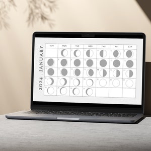 May include: A laptop screen displaying a calendar for January 2024 with moon phases illustrated for each day.
