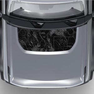 May include: A silver car with a black sunroof. The sunroof has a black and white map design.