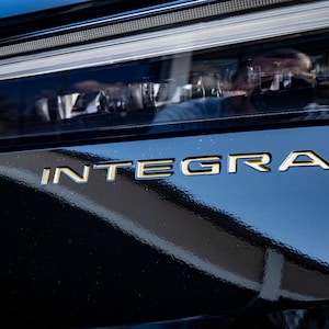 Könnte beinhalten: Nahaufnahme eines schwarzen Autos mit dem Schriftzug "INTEGRA" in goldenen Buchstaben am Heck.