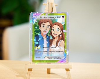 May include: A clear acrylic card with a cartoon couple illustration, displayed on a small wooden easel. The card reads "Love Th. Anniversary 2025" and "Power Couple". The card also has the text "This couple is capable of tackling any obstacles that come their way."