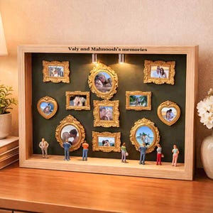 Puede incluir: Una caja de sombra de madera con m&uacute;ltiples fotos enmarcadas en oro de varias formas y tama&ntilde;os. Las fotos est&aacute;n dispuestas sobre un fondo verde oscuro. Se colocan figuras en miniatura en la parte inferior. El texto "Valy and Mahnoosh's memories" est&aacute; en la parte superior.