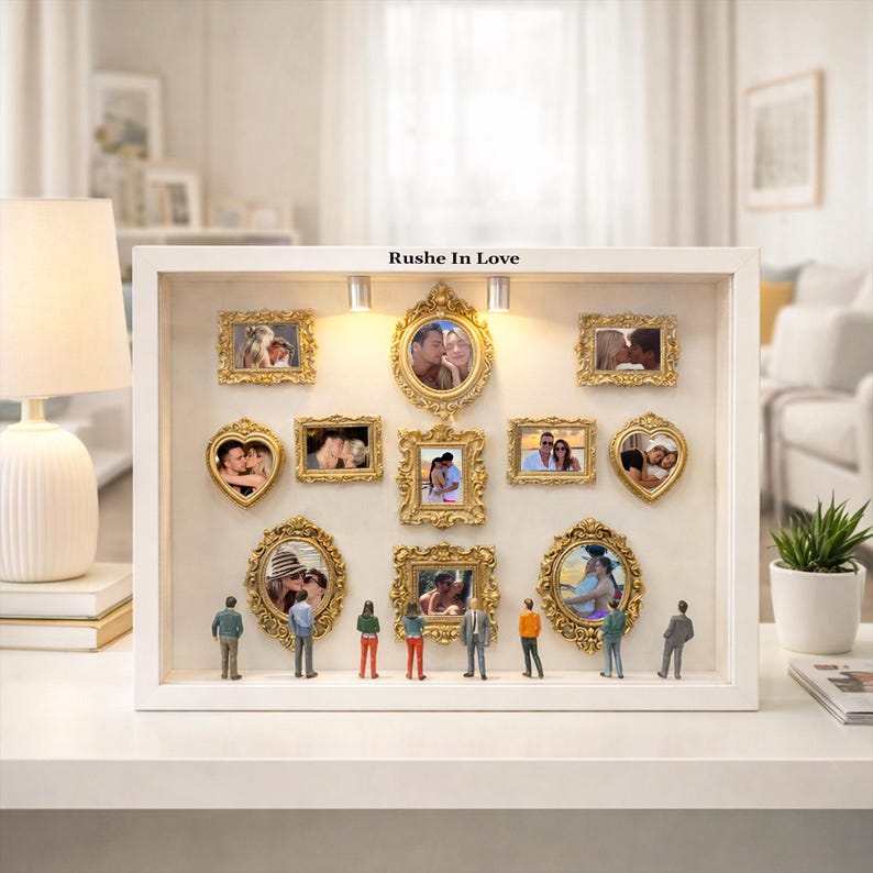 Puede incluir: Una caja de sombra blanca con m&uacute;ltiples fotos de parejas enmarcadas en oro. Las fotos tienen varias formas, incluyendo rectangulares y en forma de coraz&oacute;n. El texto "Rushe In Love" est&aacute; encima de las fotos. Figuras en miniatura est&aacute;n debajo.
