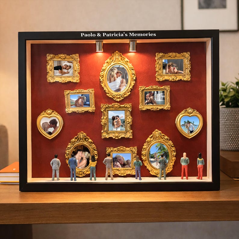 Puede incluir: Una caja de sombra negra con fotos enmarcadas en dorado sobre un fondo rojo. El texto "Paolo & Patricia's Memories" est&aacute; en la parte superior. Figuras en miniatura se colocan debajo de las fotos.