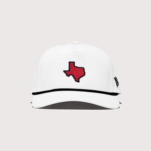 May include: White baseball cap featuring a red Texas state outline. The cap has a black rope detail along the brim and a mesh back. A stylish accessory for fans of Texas.