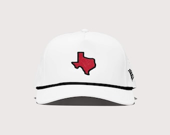 Puede incluir: Gorra de béisbol blanca con un contorno rojo del estado de Texas. La gorra tiene un detalle de cuerda negra a lo largo del borde y una parte trasera de malla. Un accesorio elegante para los fanáticos de Texas.